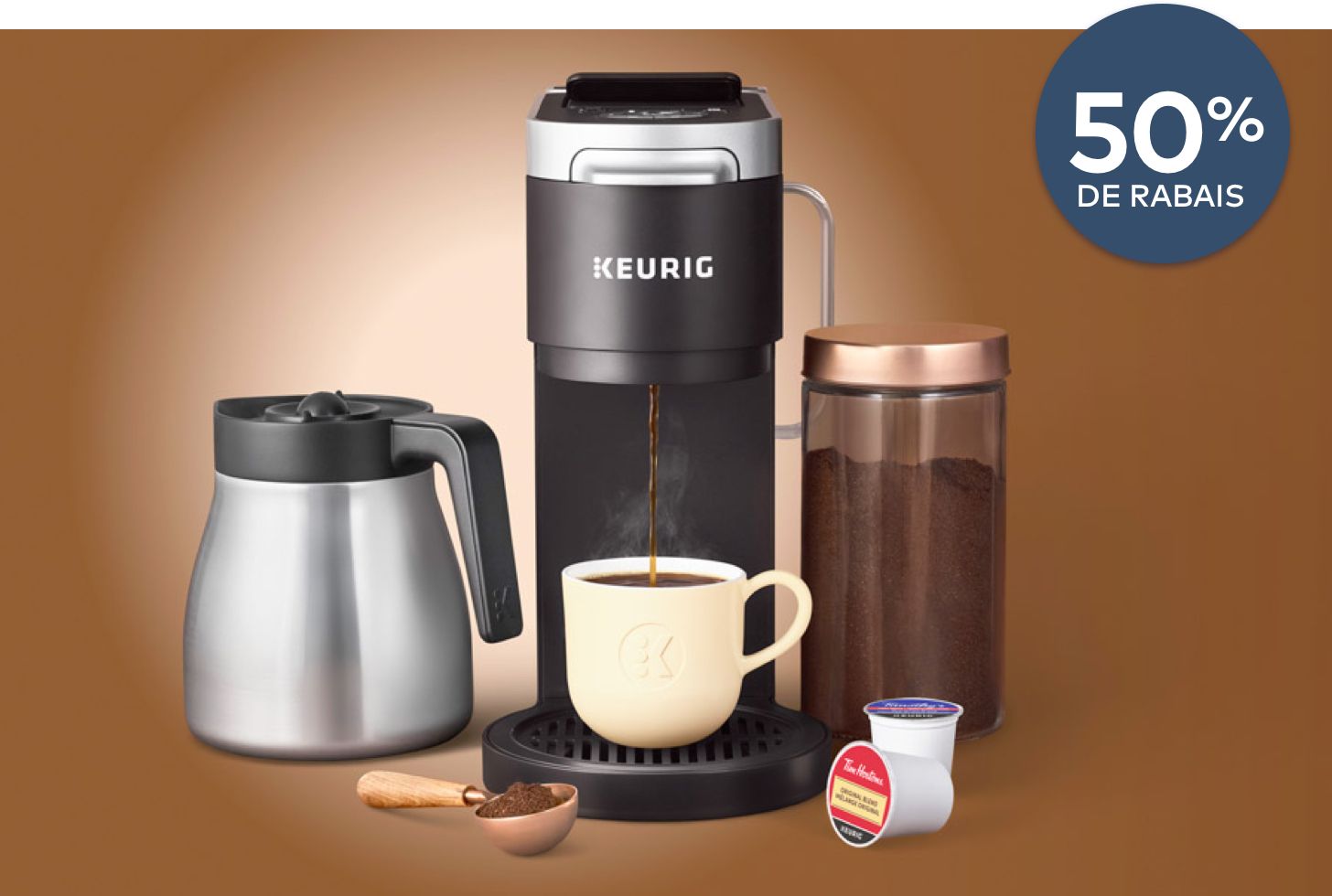 L'image montre un kit de démarrage de cafetière Keurig avec une tasse de café et une cuillère à côté